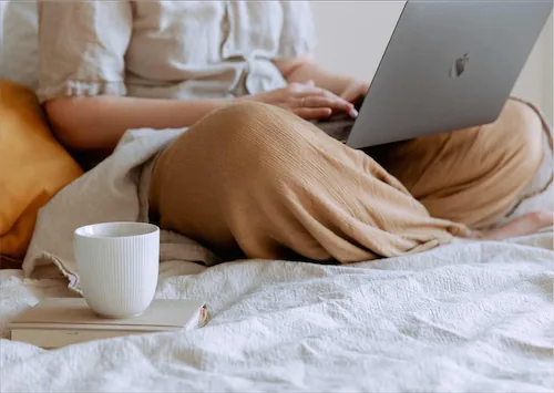 Cross leged with computer on lap and coffee