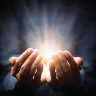 Hands held up with light shining through