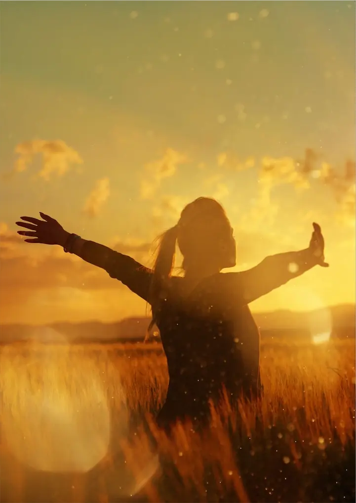 Lady with pony tail arms stretched out towards sun